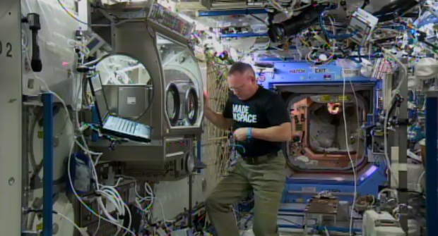 ISS Commander Barry “Butch” Wilmore installs the 3D printer in the Microgravity Science Glovebox.